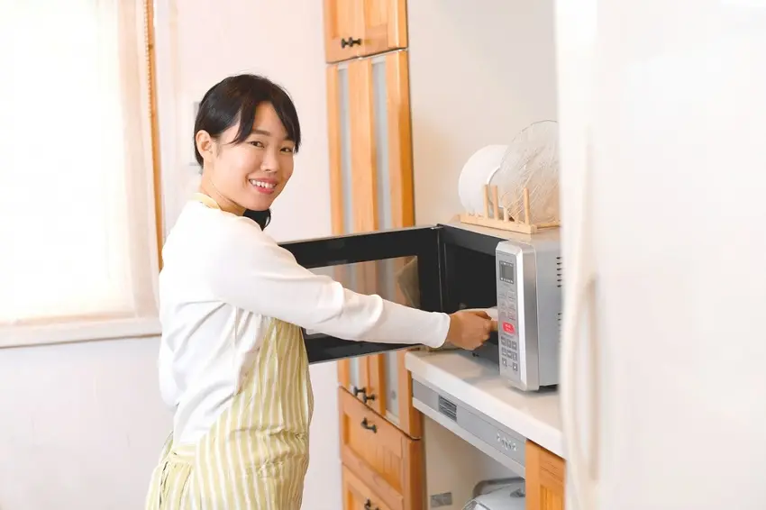 電子レンジを開ける女性