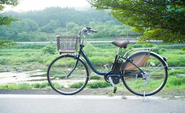 自然あふれる背景と電動自転車